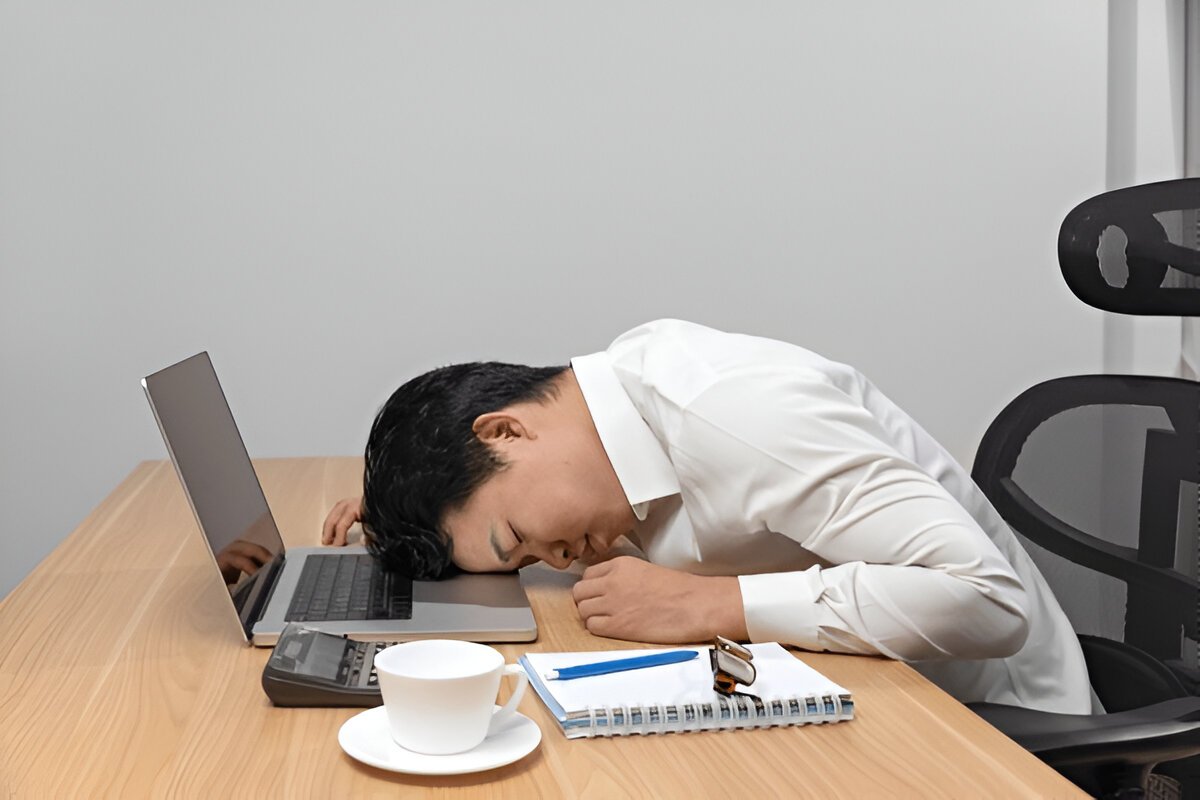 A man falling asleep on his laptop while working