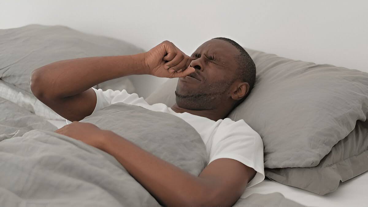 A man unable to sleep due to nighttime allergies.