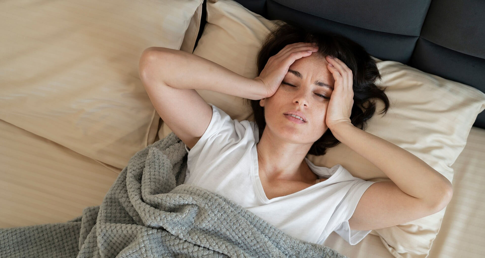 A woman seemingly suffering from a headache due to lack of proper sleep.