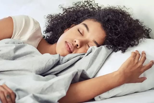 A woman sleeping, resting on a white pillow