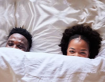 a couple in bed under a weighted blanket