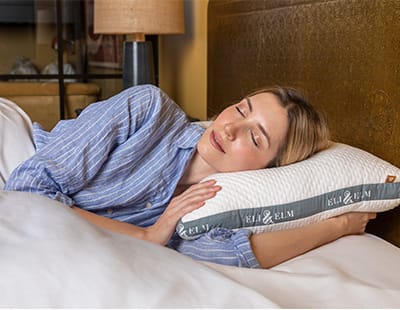 A women resting her head on Eli & Elm side sleeping pillow