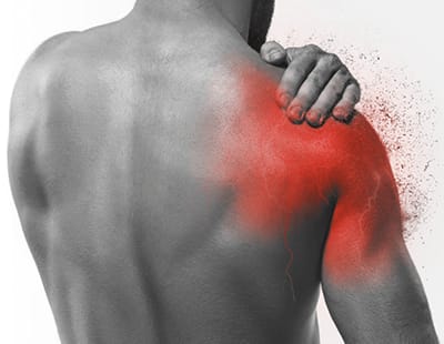 A man holding his shoulder, indicating pain or discomfort.