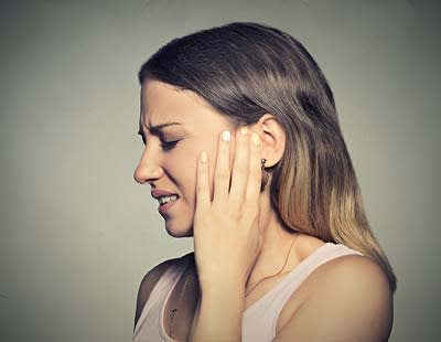 A woman suffering from some sort of ear pain
