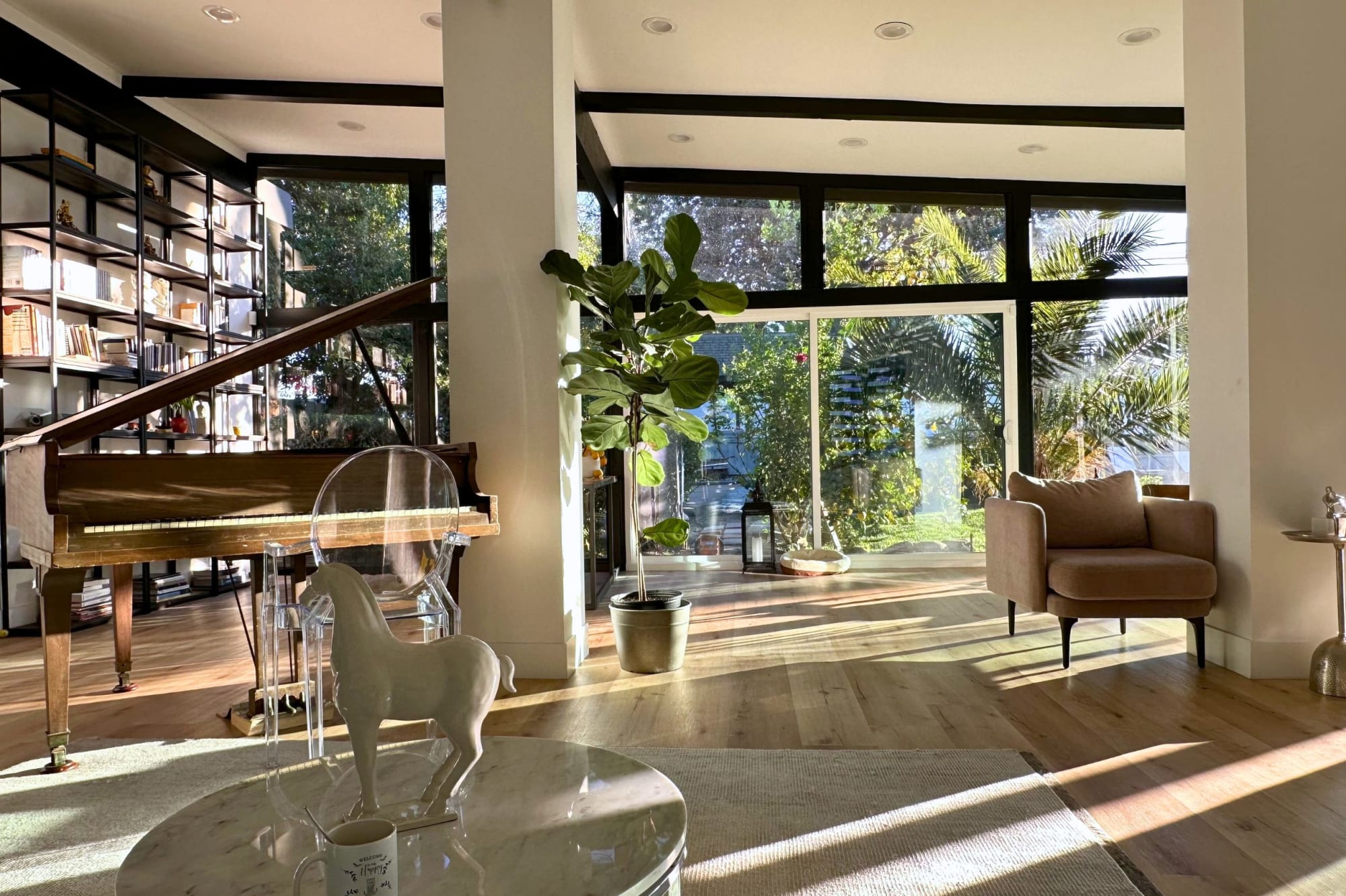 Floor-to-ceiling glass wall dissolving the boundary between living room and garden.