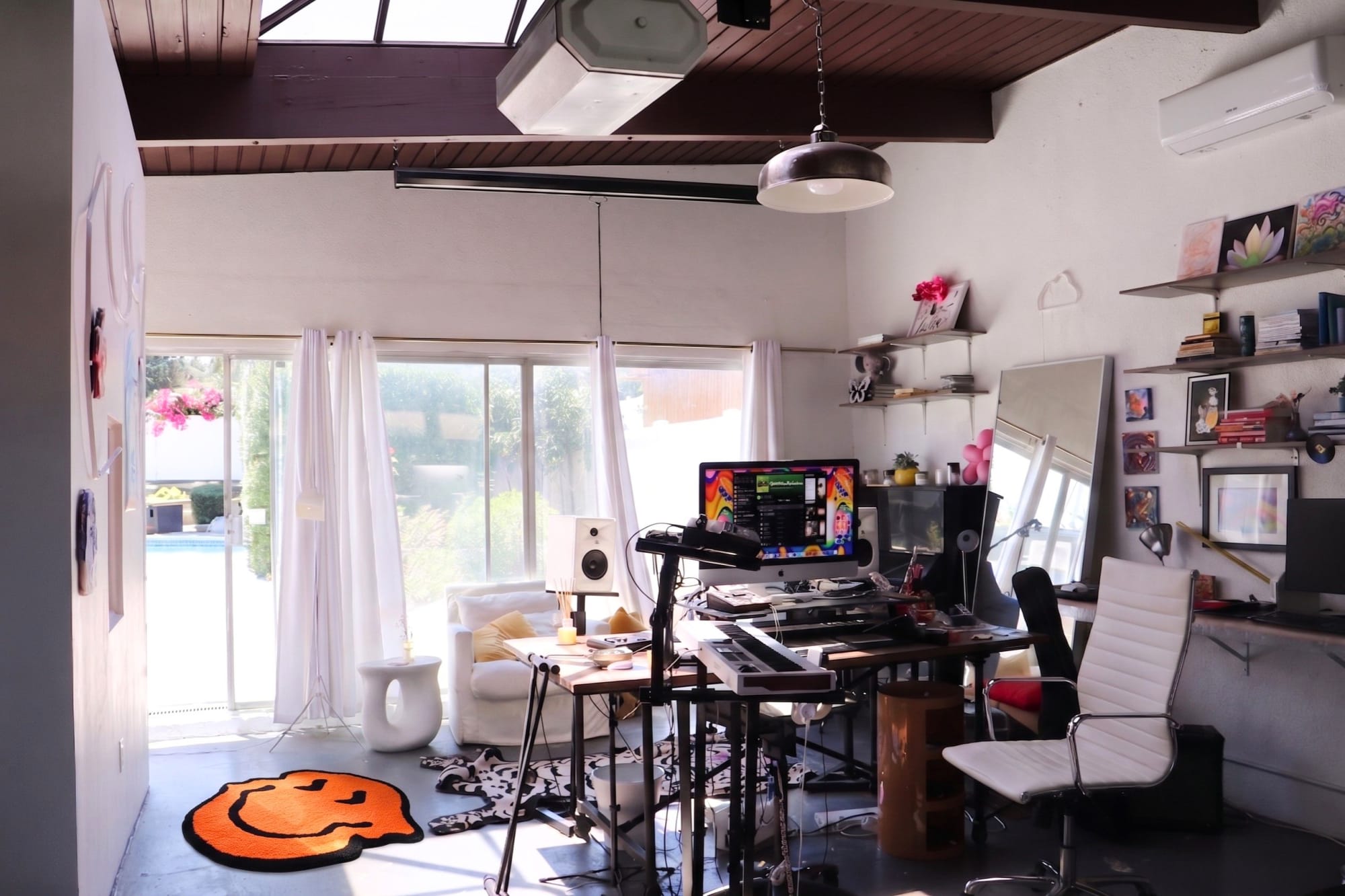 The studio space with wood beams, a skylight, and soft natural light — a room built for focused creative work.