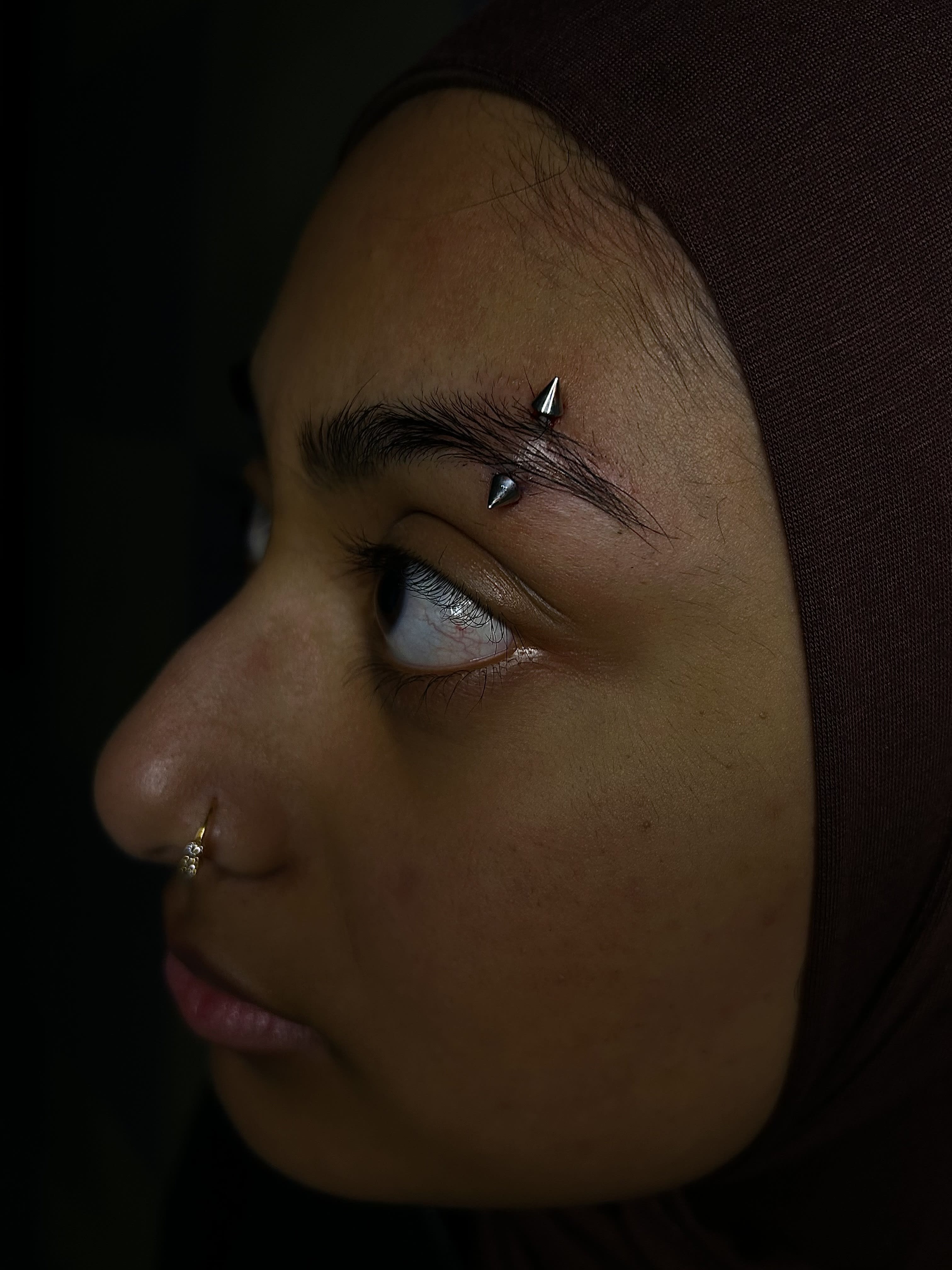 Fresh 14g double spike, titanium eyebrow piercing.