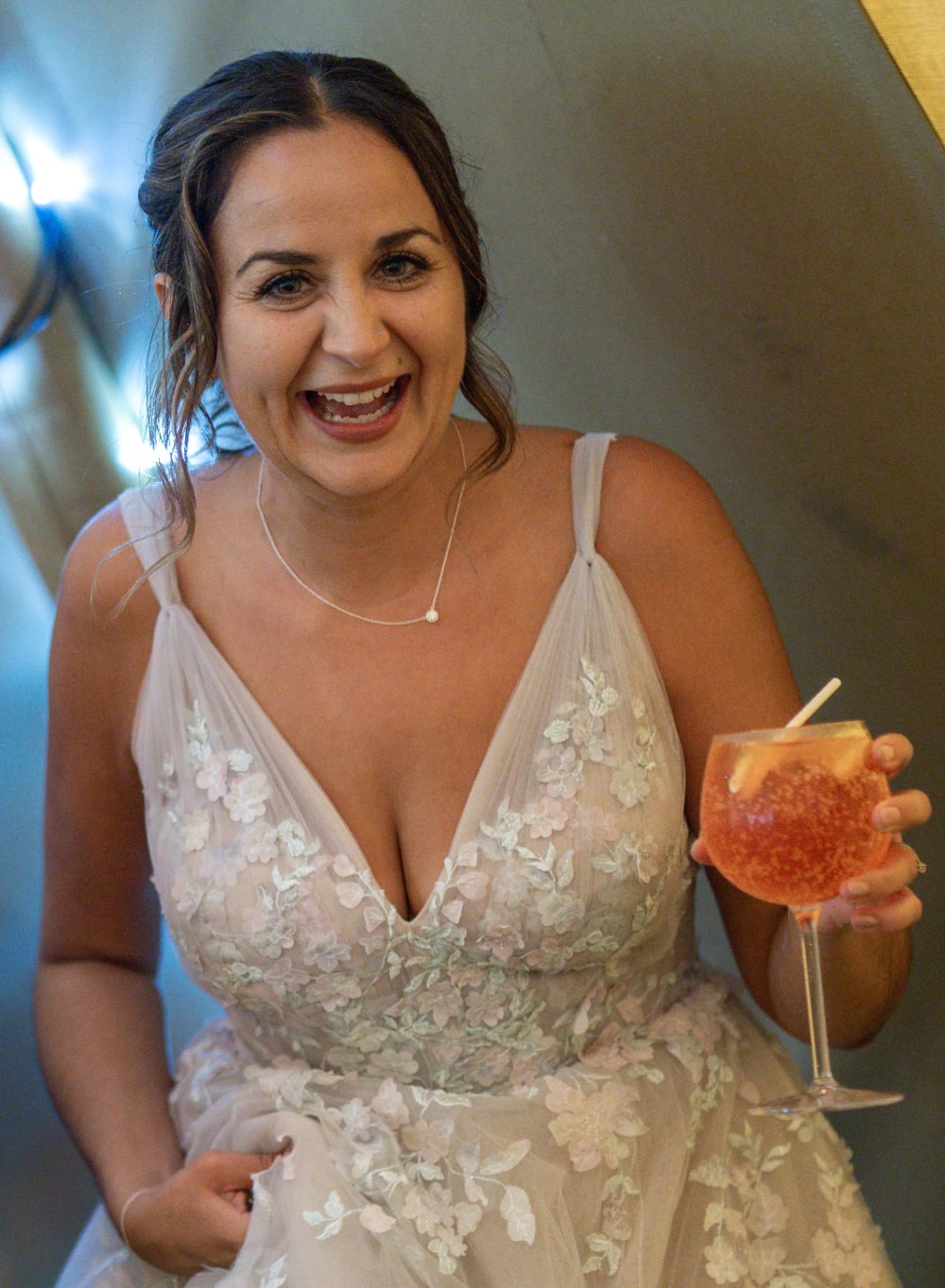 Bride laughing with a drink in hand