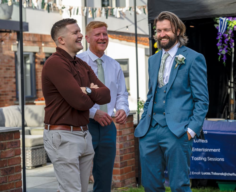Groom laughing with guests