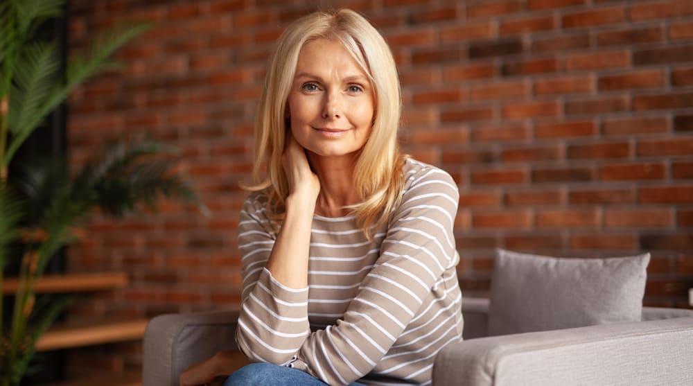 Confident mature woman with natural-looking facial rejuvenation results in a comfortable home setting