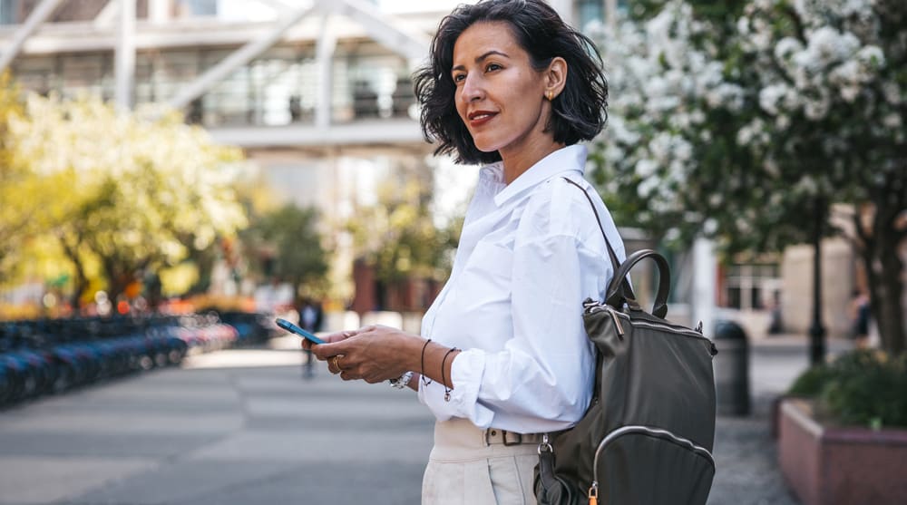 Confident woman with refreshed, natural facial appearance walking outdoors in an urban setting after aesthetic treatment