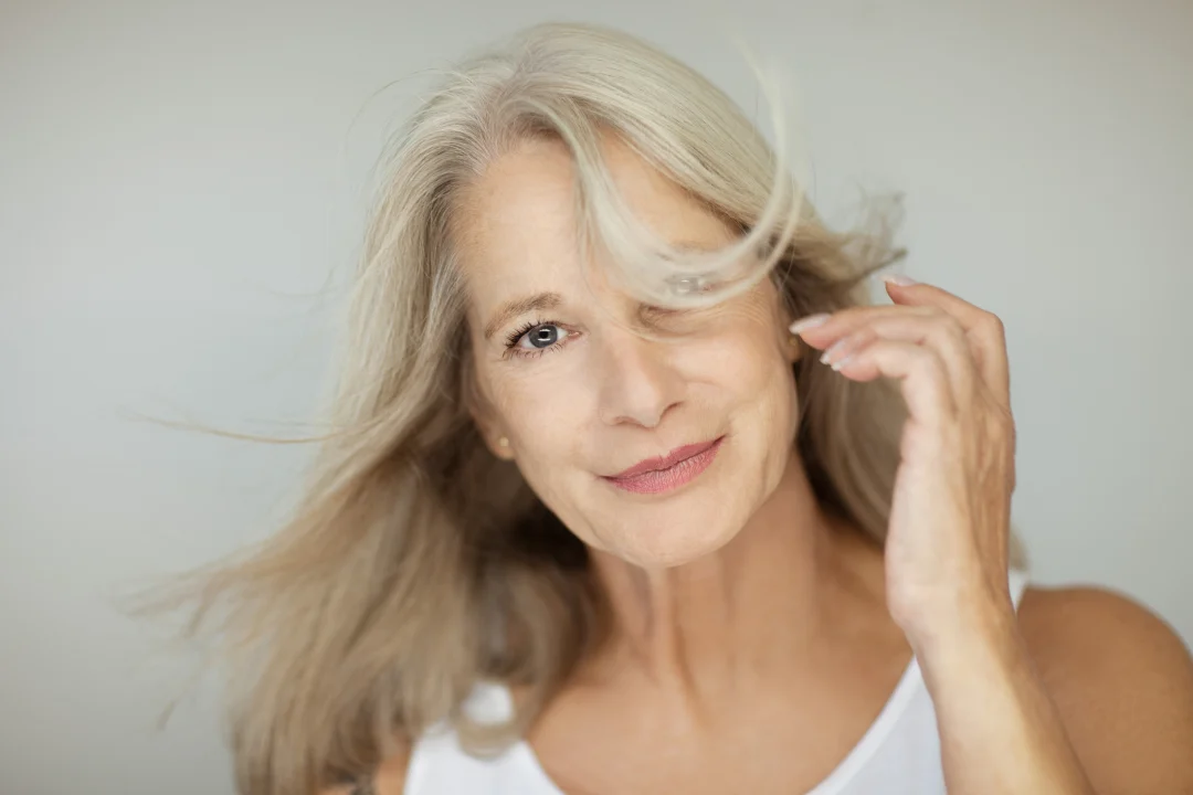 Mature woman with smooth, rejuvenated facial skin illustrating AVAVA skin tightening laser treatment.