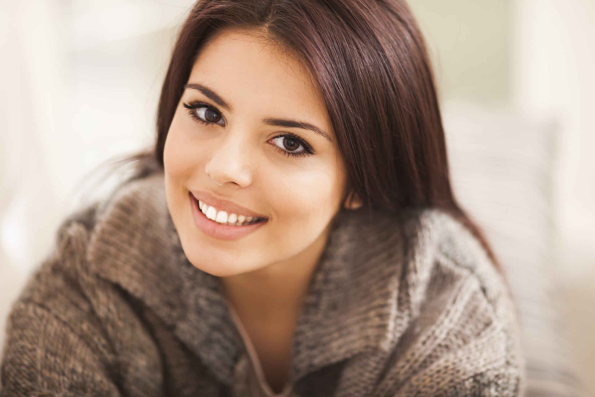 Rhinoplasty: Smiling young woman with balanced facial features and dark hair