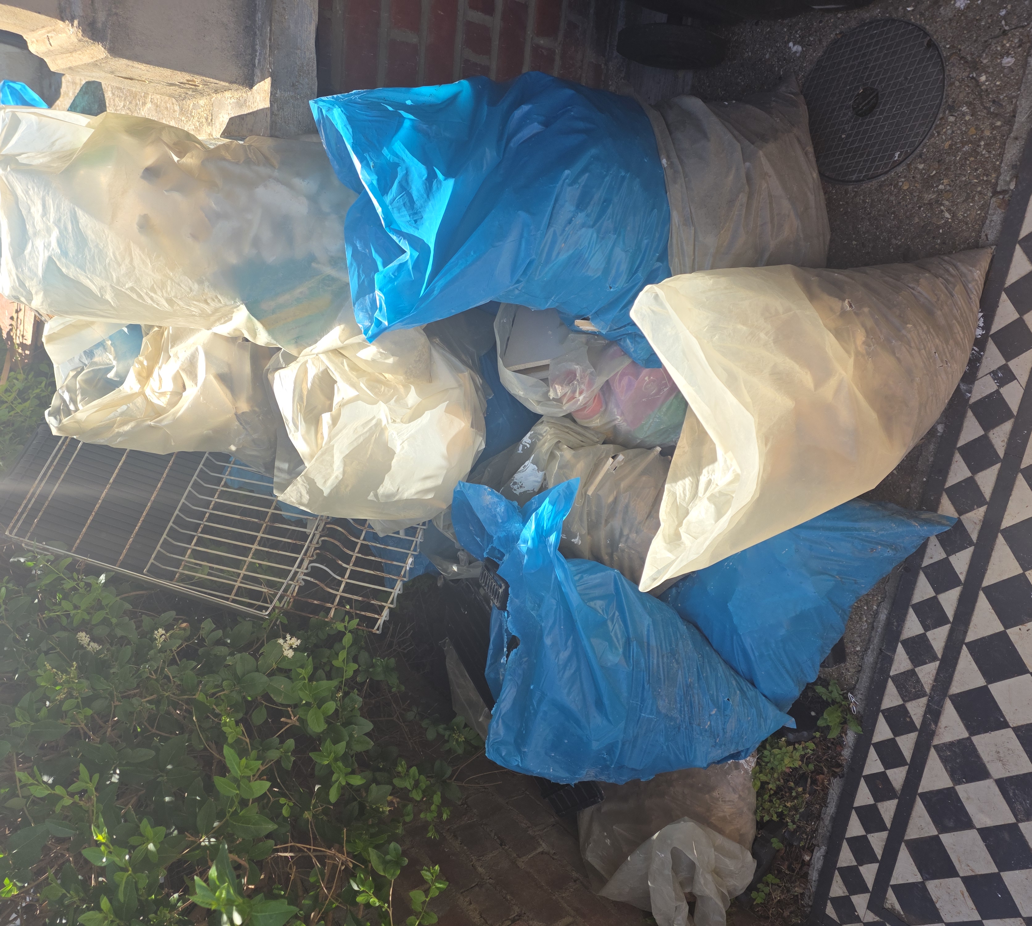 Bathroom renovation waste bags stacked outside Hackney property