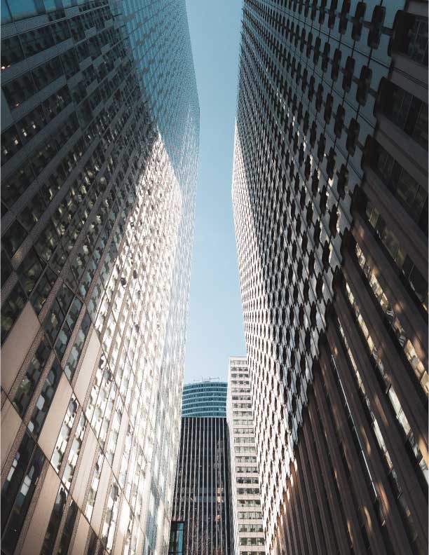 looking up at several tall office buildings