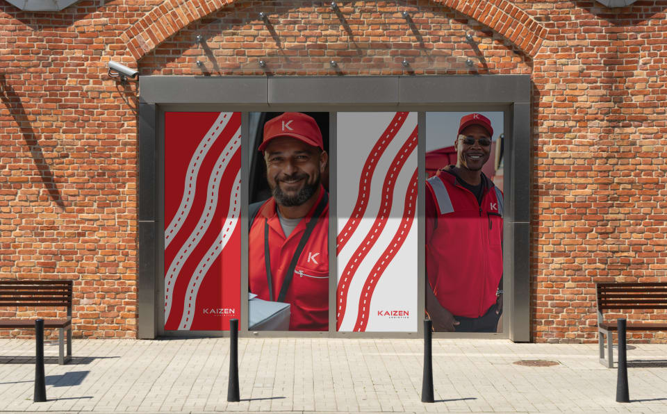 Kaizen portraits and flowing road graphics across a storefront entrance