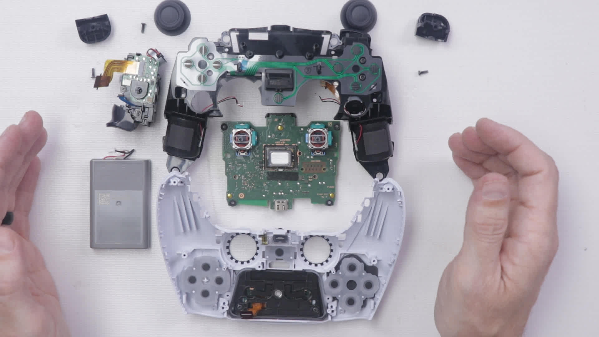 Opened DualSense controller showing the internal board and both analogue stick modules