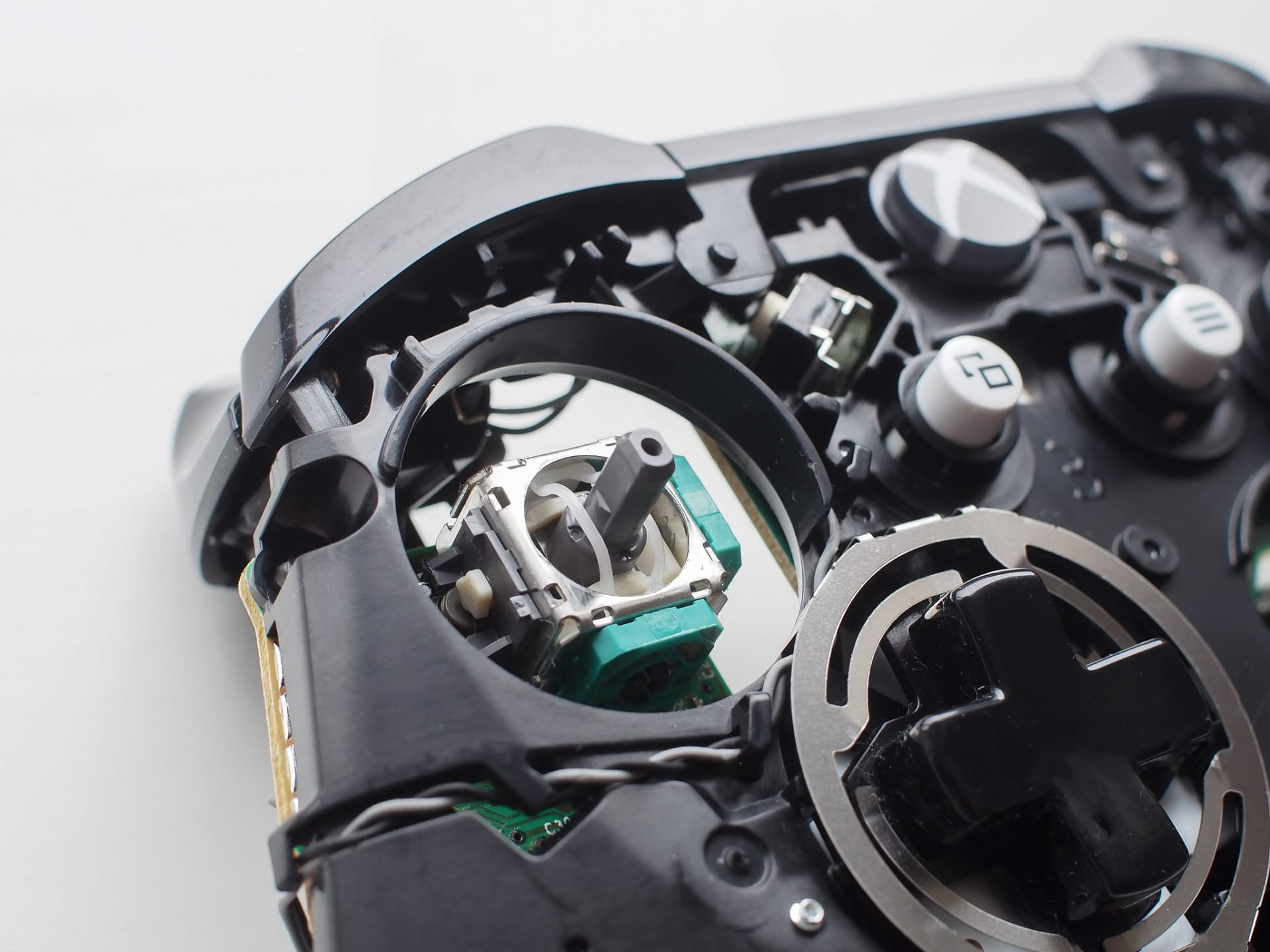 Close up of a controller analog thumbstick module showing the potentiometer assembly underneath