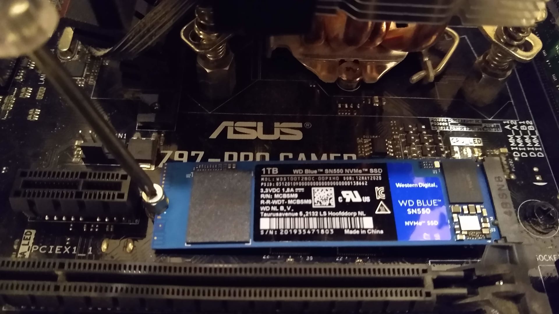 Fitting an NVMe M.2 solid state drive into a motherboard slot under the heatsink