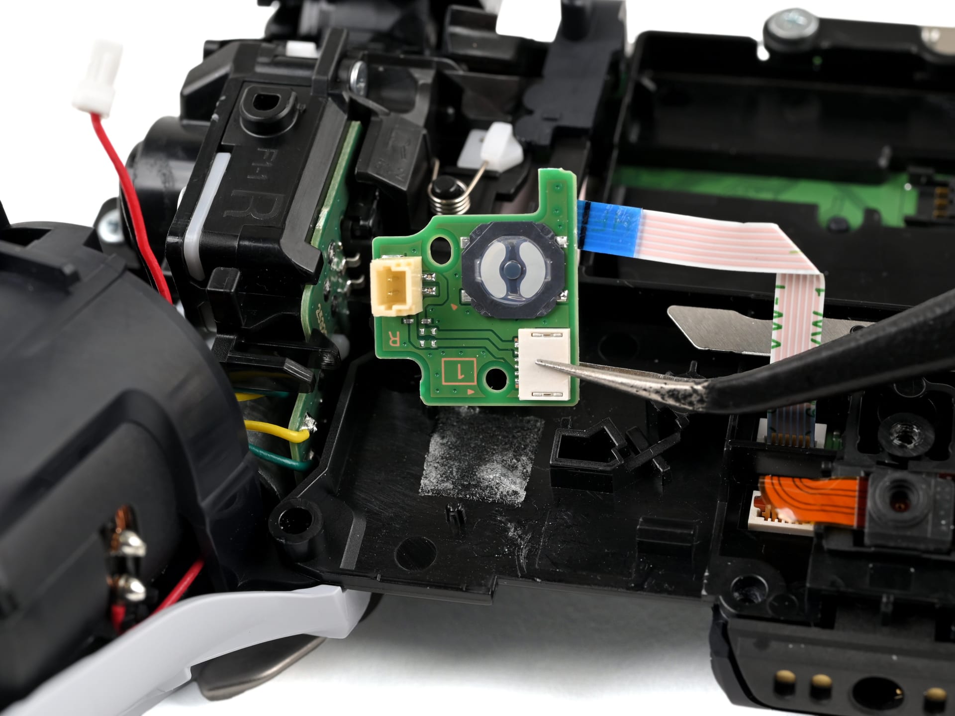 The small reset pinhole on the rear of a DualSense controller near the Sony logo