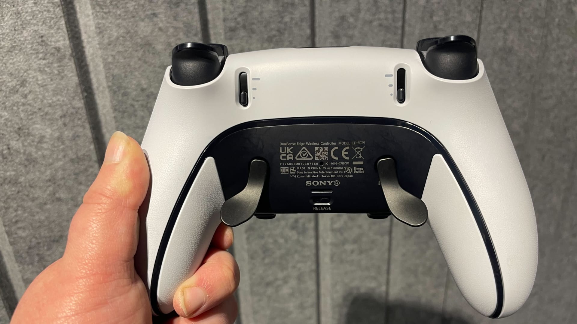 Rear view of a DualSense wireless controller showing the grips and trigger assembly