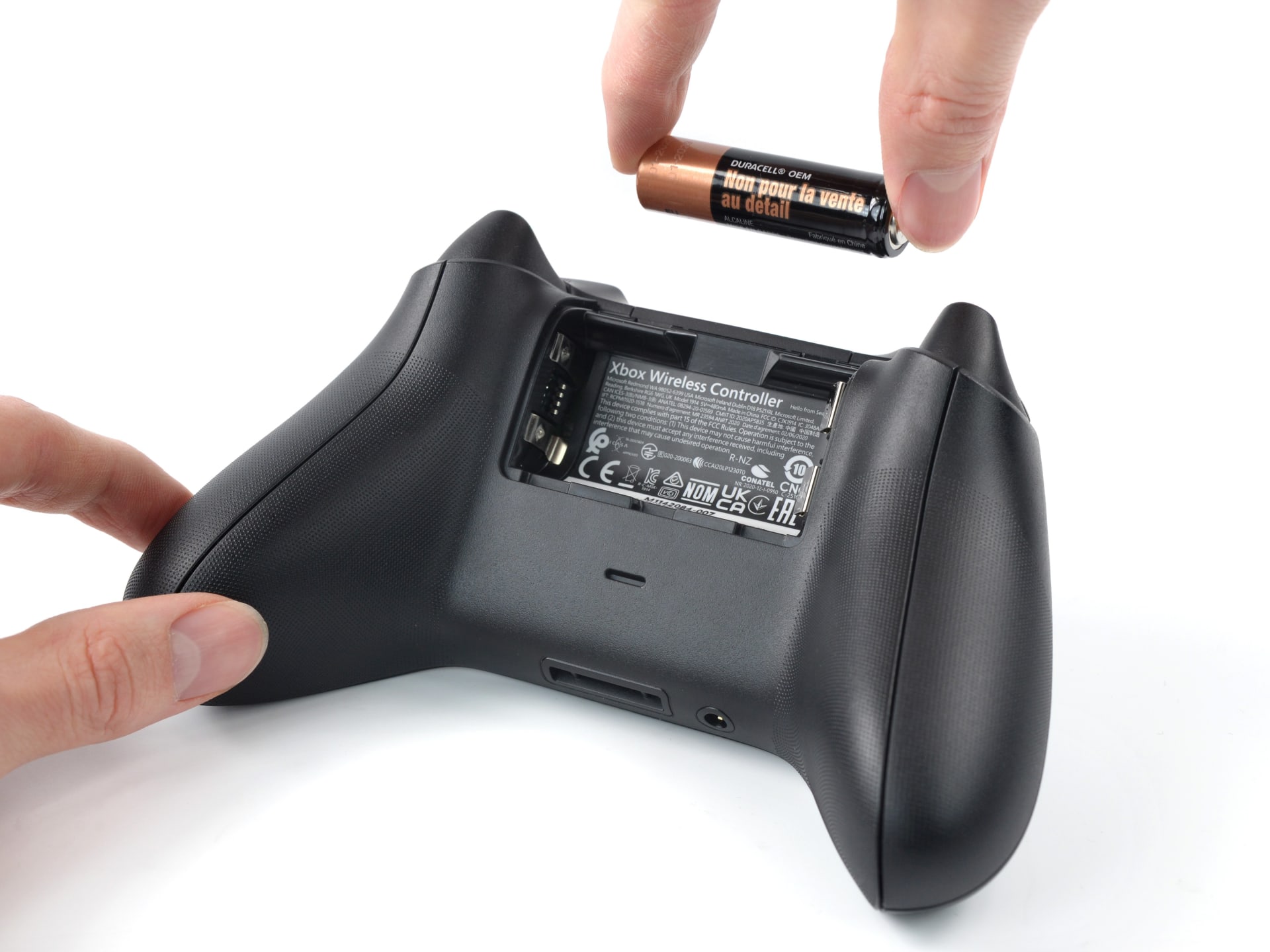 The battery compartment of an Xbox controller opened to show the two AA cells inside
