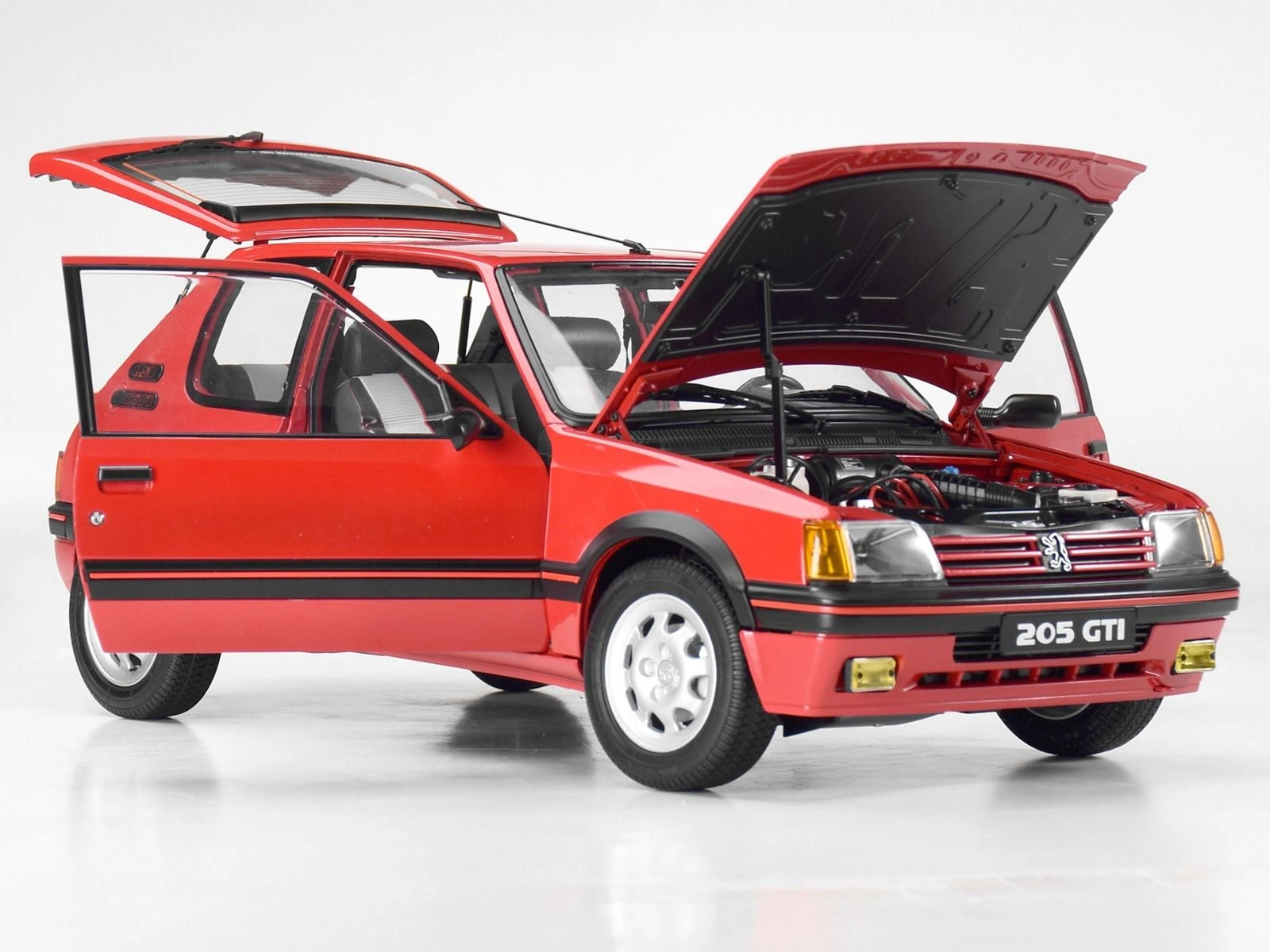 Front-side view of an assembled Peugeot 205 1.9 GTI 1/8 scale model with doors, boot and bonnet open