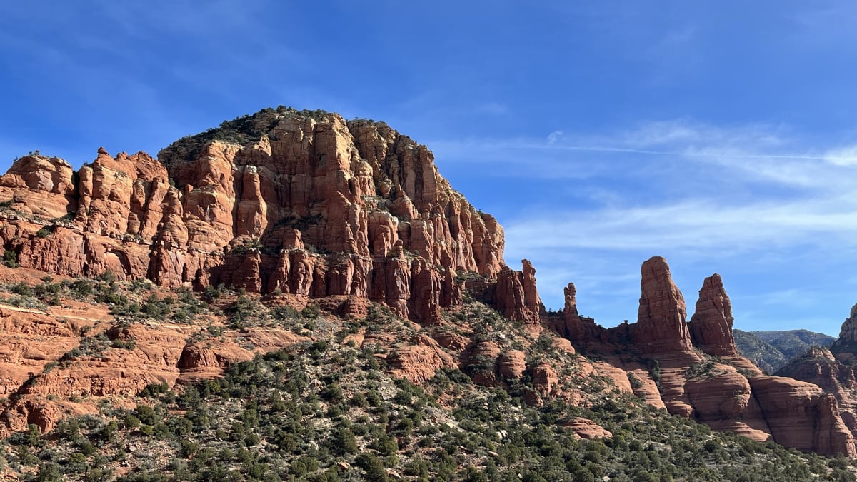A red sandstone spire rising above the pinyon and juniper near Bell Rock