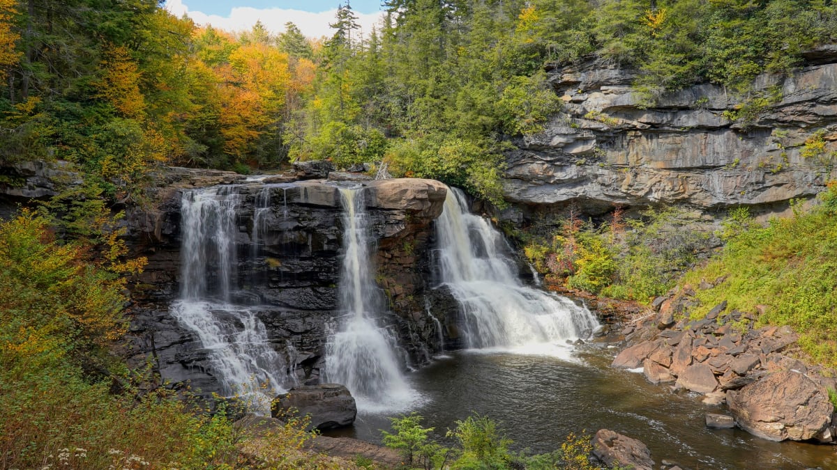 The amber waters of Blackwater Falls tumbling over rock ledges in Blackwater Falls State Park, West Virginia