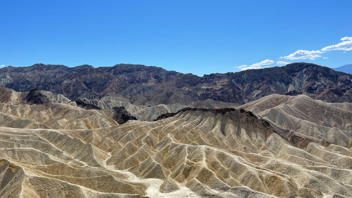 Golden eroded badlands and Manly Beacon seen from Zabriskie Point, Death Valley National Park, California