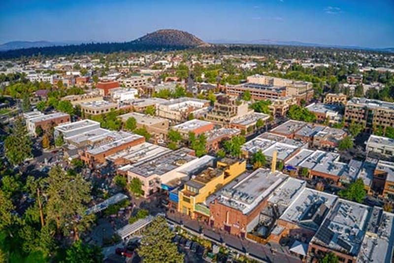 Downtown Bend, Oregon along the Deschutes River with independent shops, restaurants, and breweries on a sunny day