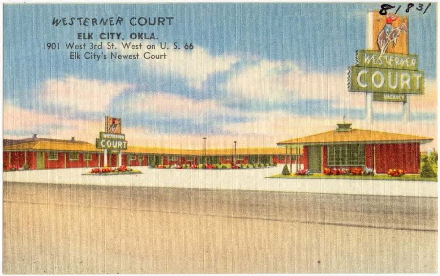 A vintage linen postcard of the Westerner Court motor court, with a cowboy neon sign, on U.S. Route 66 in Elk City, Oklahoma
