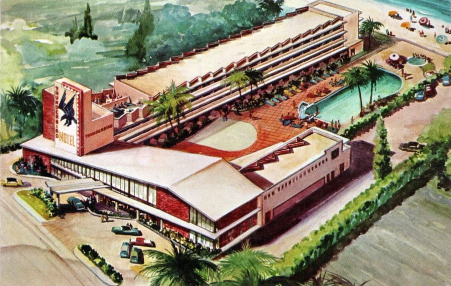 A 1956 color postcard of the Thunderbird Motel in Miami Beach, a low mid-century modern building with a tall roadside sign and palm trees.