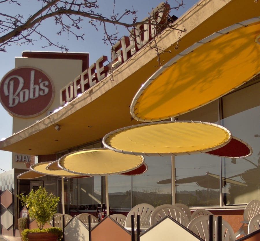 The Googie-style Bob's Big Boy coffee shop in Burbank, California, with its upswept roof, cantilevered sign, and a cascade of oval patio umbrellas