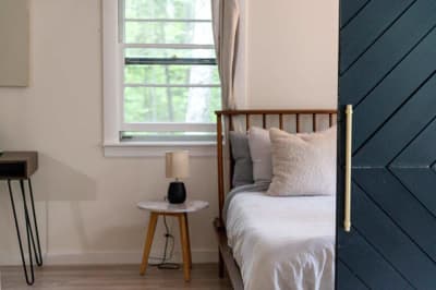 Characterful boutique motel room with blue barn door and warm natural light. Affordable private entrance and design intent