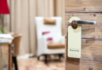 Do Not Disturb sign on a wood-paneled motel door. Private entrance, cozy affordable motel with character