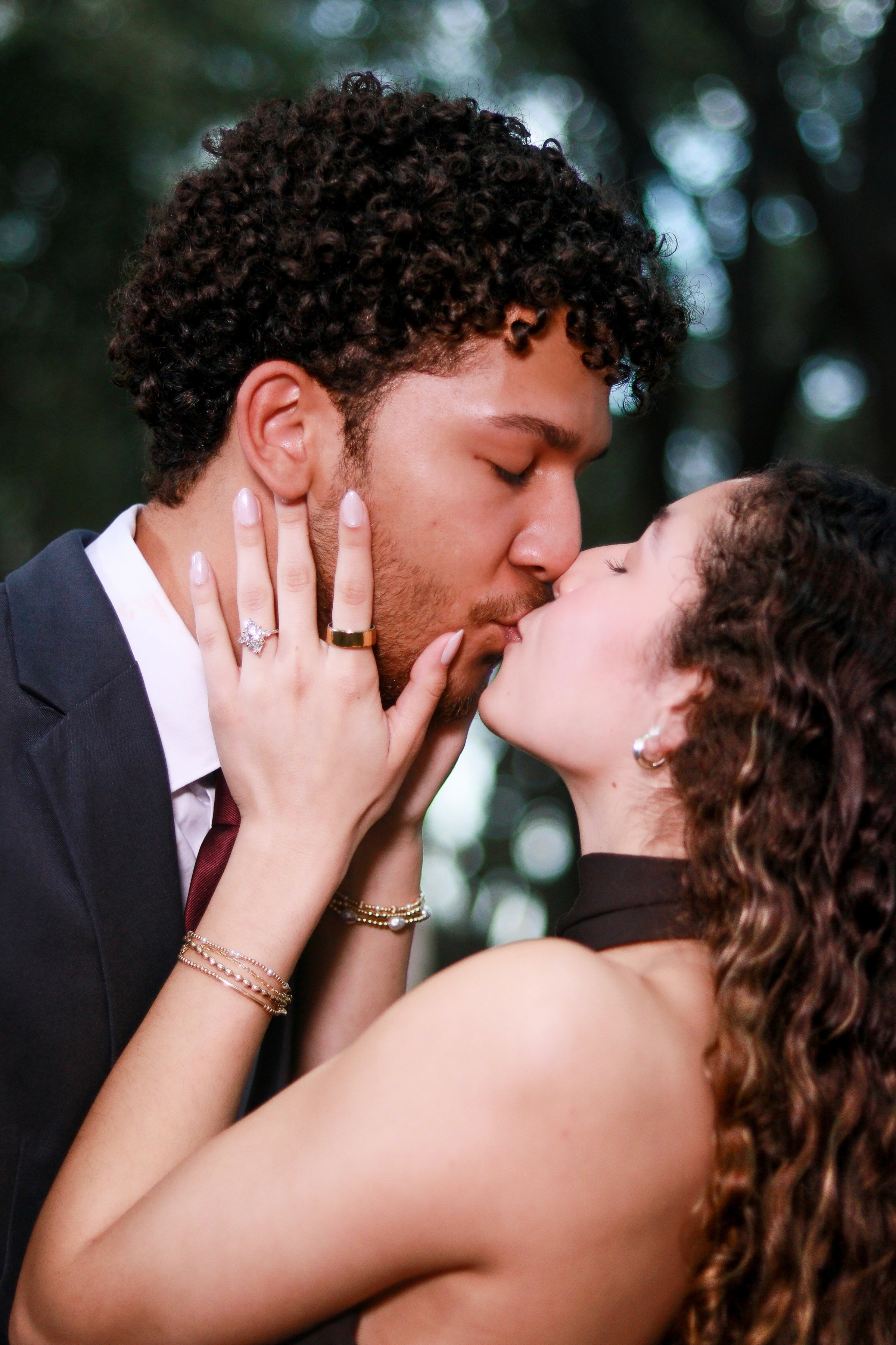 Couple kissing with the engagement ring in view