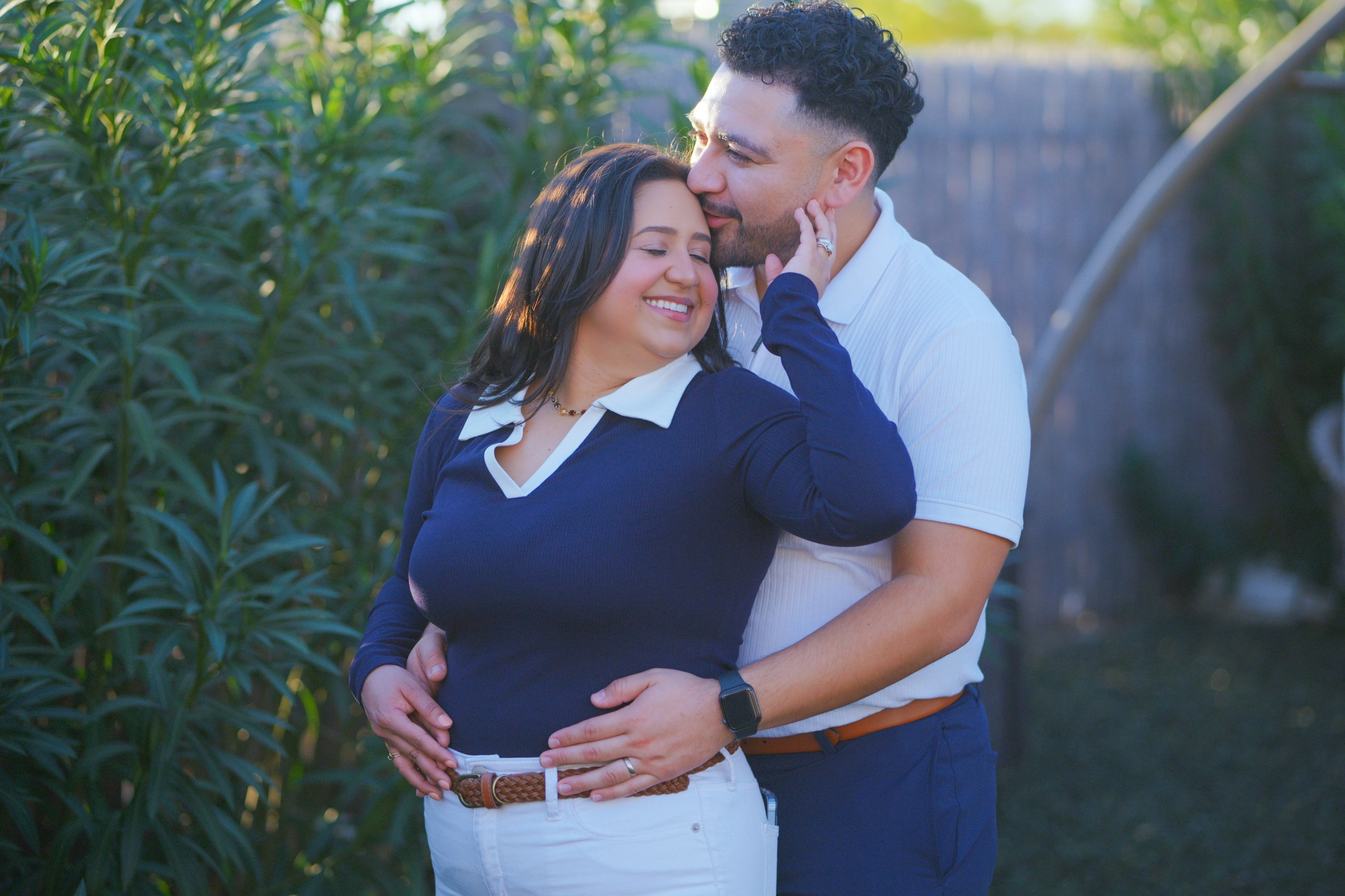 Couple embracing among lush green trees
