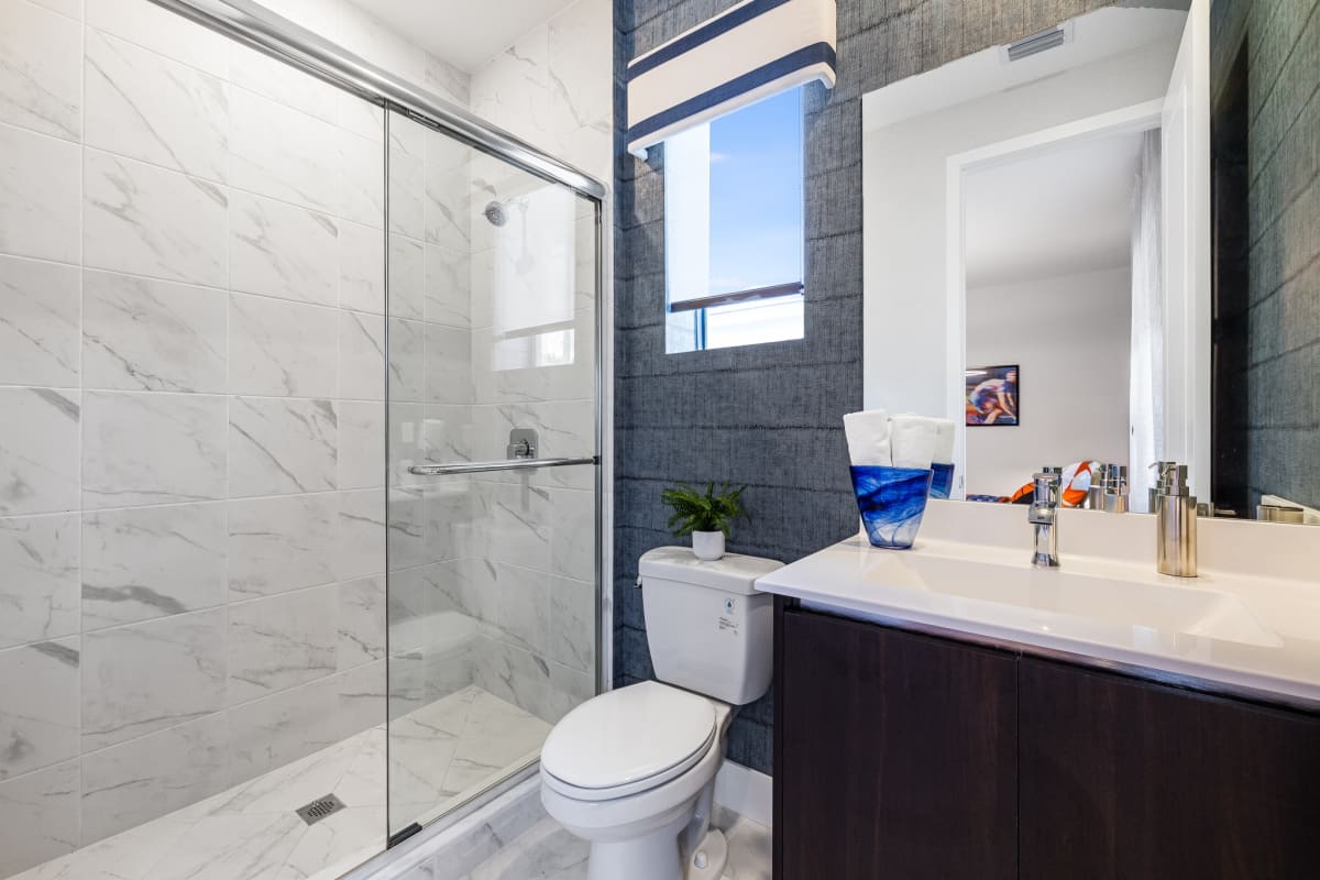 Elegant tiled shower with stone finishes demonstrating custom tile work and high-end bathroom design