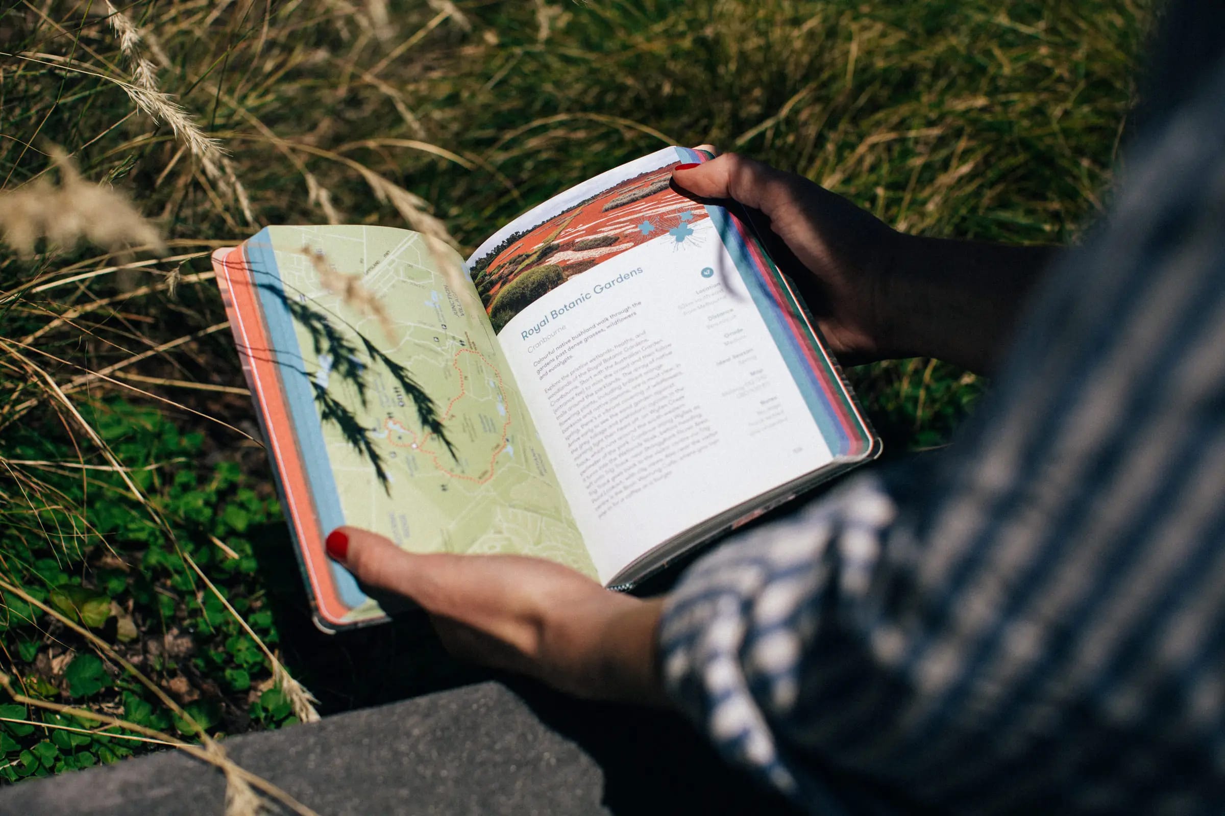 Women holding 'walks in nature' book with open pages and map