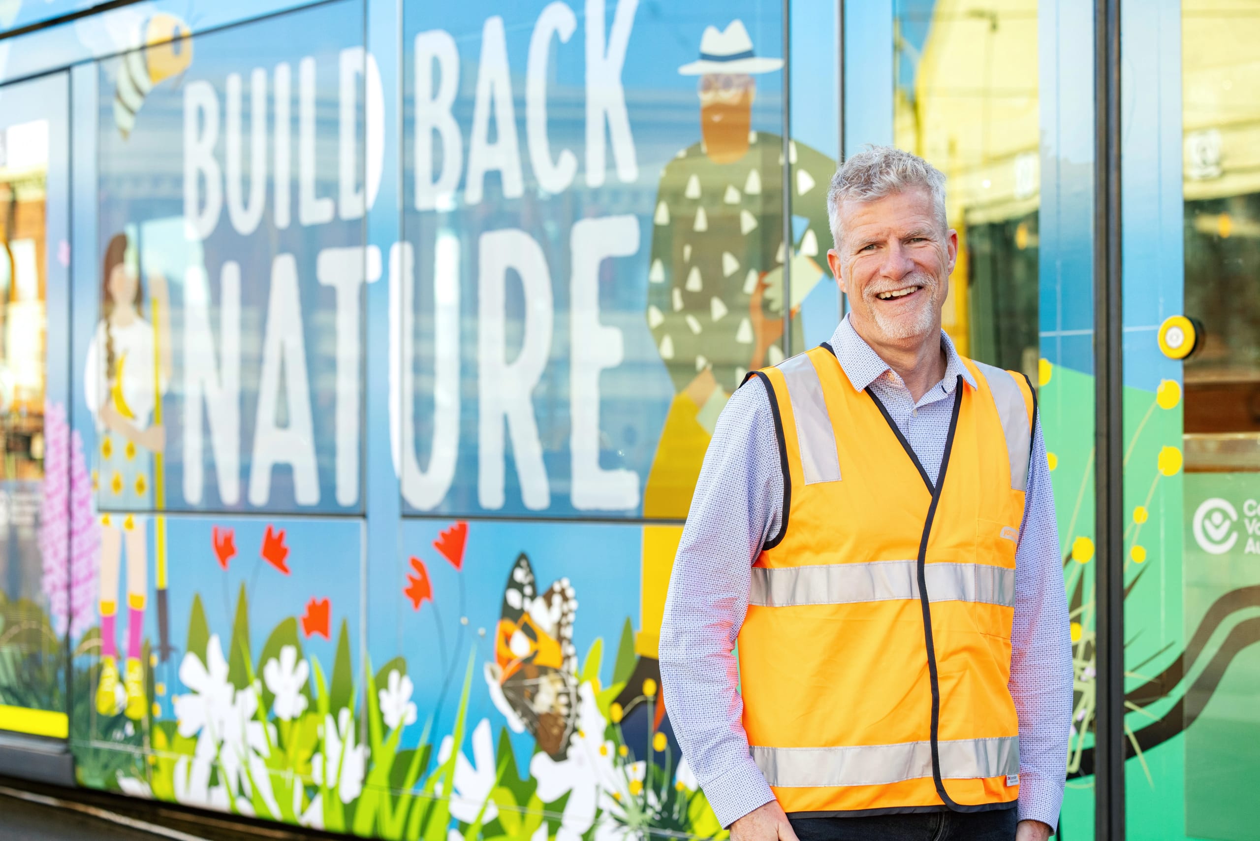 Man standing in front of Melbourne tram with illustrations
