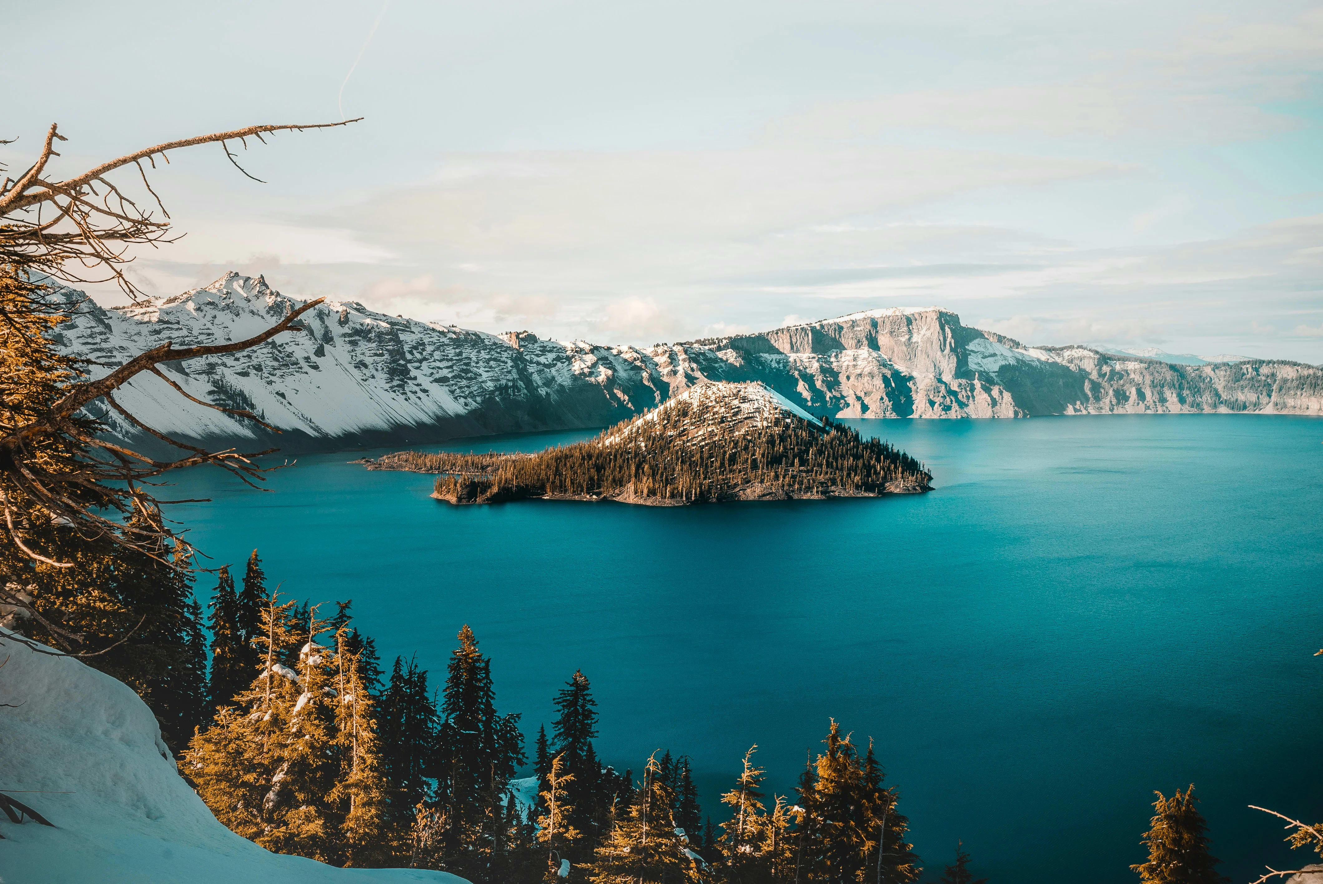 Crater Lake Oregon showing deep blue volcanic lake with Wizard Island and snow-dusted crater rim