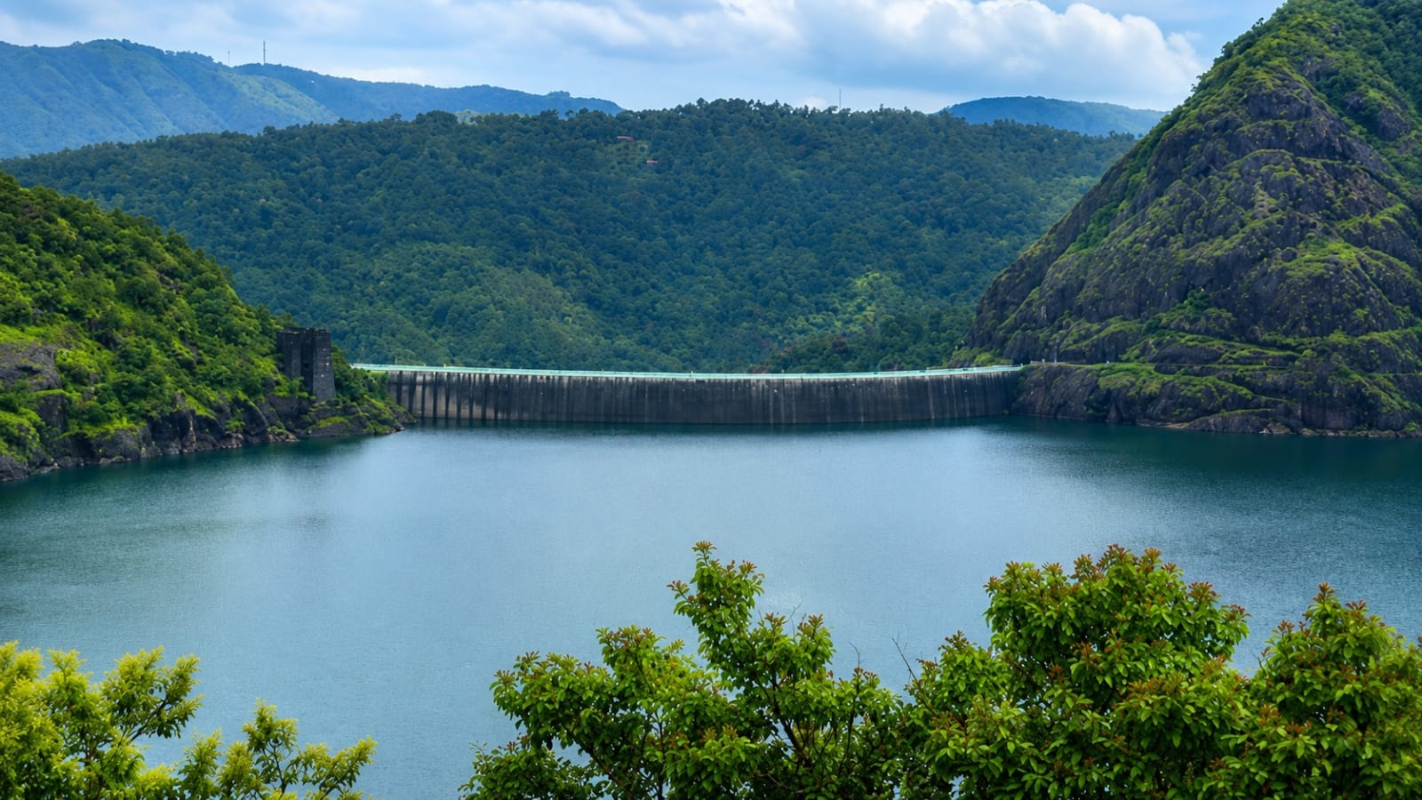 Scenic view of Idukki Arch Dam surrounded by hills and reservoir in Kerala