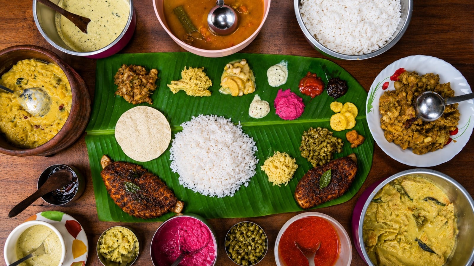 Full Kerala lunch spread on banana leaf served on Alleppey houseboat — karimeen, rice, avial, sambar