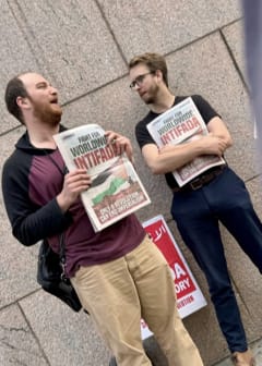 Protestors holding papers that read "Fight for worldwide Intifada"