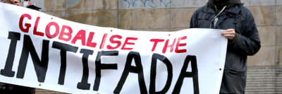 Protesters holding a ‘Globalize the Intifada’ placard
