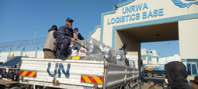 Hamas policemen guarding an aid truck as it reaches the UNRWA logistics base in Rafah