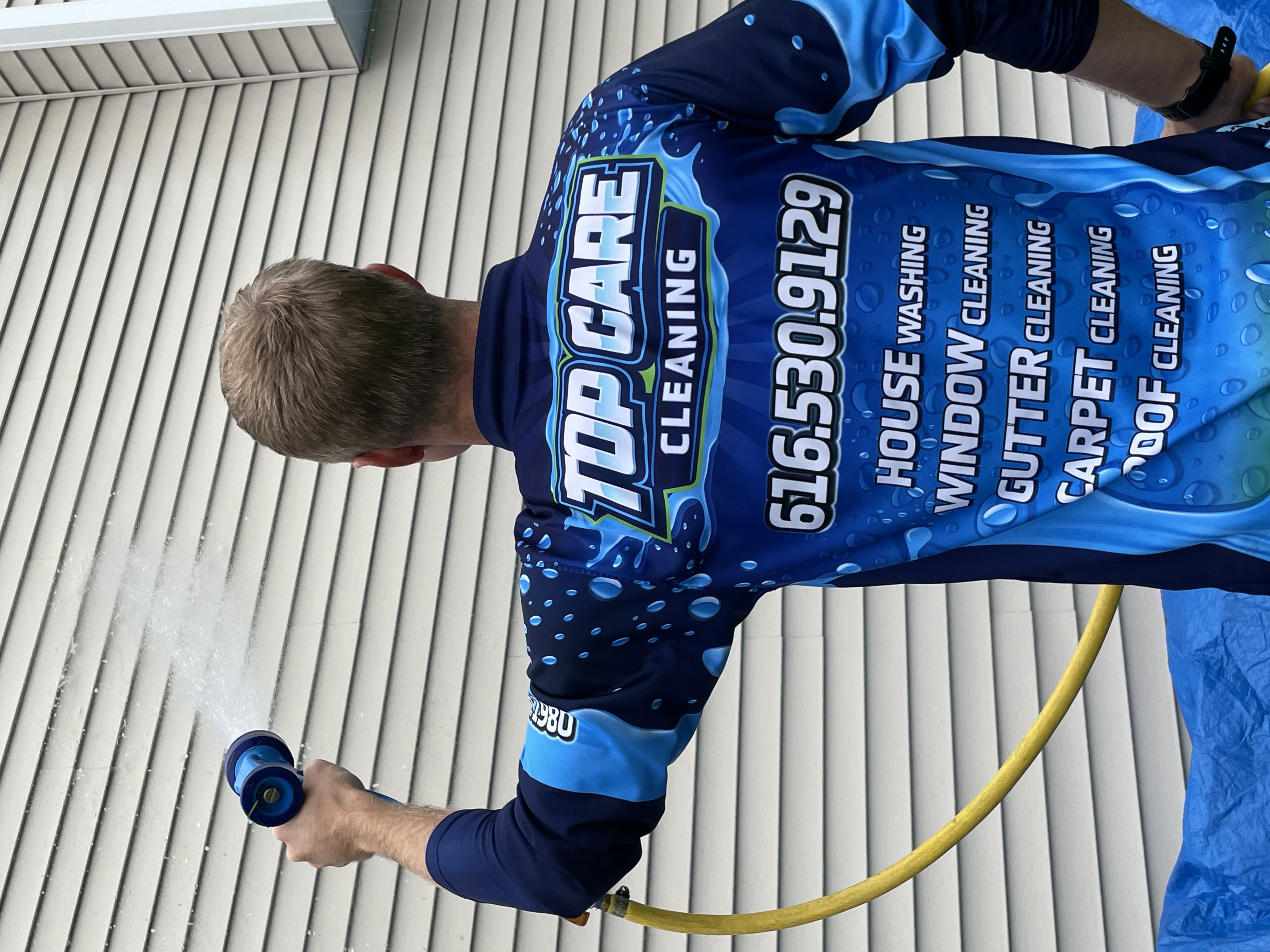 Top Care Cleaning house wash technician rinsing — Grand Rapids, MI