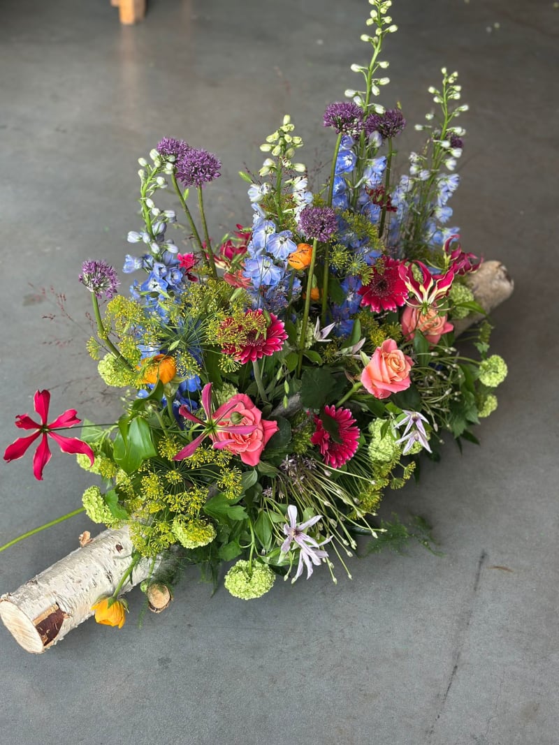 Rouwbloemwerk op een berkenstam, samengesteld door Atelier Bloeiend in Dronten