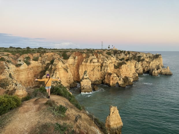 Rosalie standing along the shoreline near Ponta da Piedade